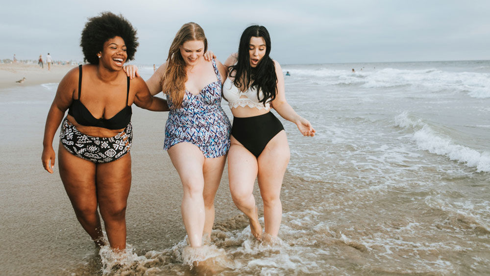 Trois jeunes femmes sur la plage, pieds dans l’eau : J’aime passer du temps avec mes amis à la plage.