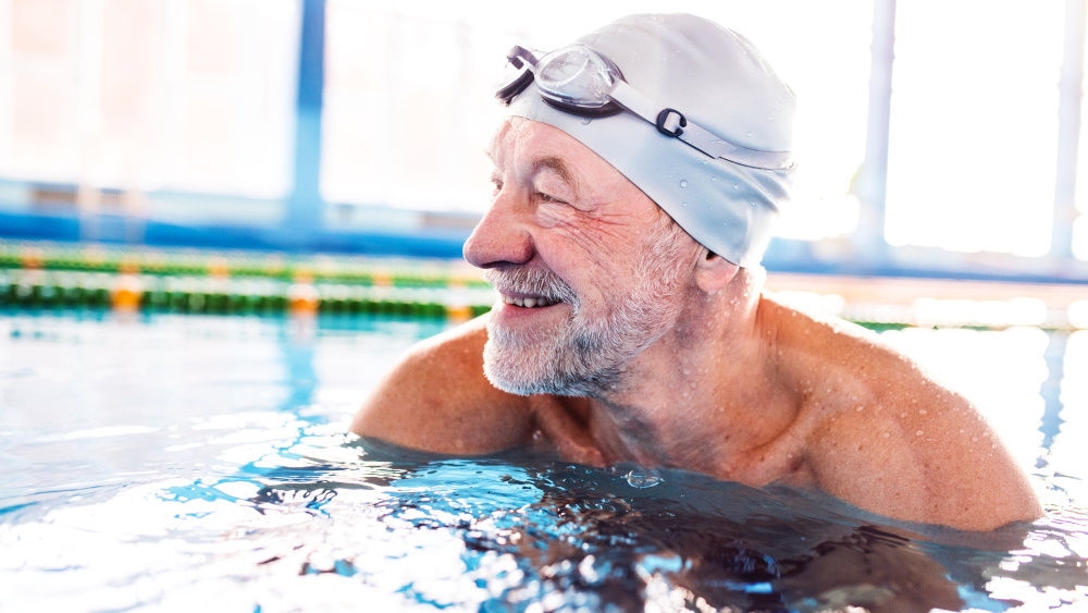 Homme âgé dans une piscine : Je suis fier d’avoir franchi cette étape. La natation est une sensation si agréable et possible avec une stomie.