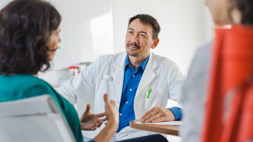 Médecin en consultation avec des patients assis au cabinet